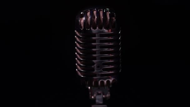 Επαγγελματικό ασημί vintage glare μικρόφωνο για εγγραφή ή να μιλήσετε με το κοινό στη σκηνή σε σκοτεινό κλαμπ κοντά. Προβολείς λάμπουν σε ένα χρωμιωμένο κλασικό ρετρό μικρόφωνο με ανταύγειες σε μαύρο φόντο. - Πλάνα, βίντεο