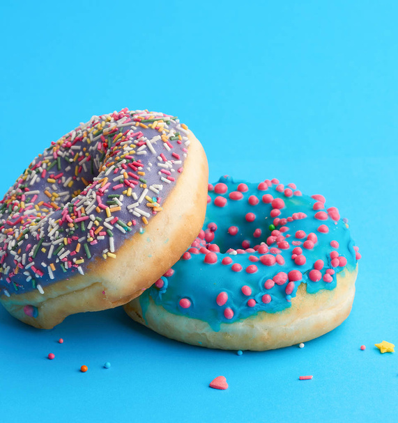два круглых пончика с цветной сахарной крошкой
  - Фото, изображение