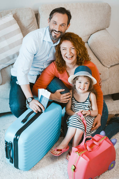 Smilig parents and little daughter setting off on vacation. - Foto, Imagen