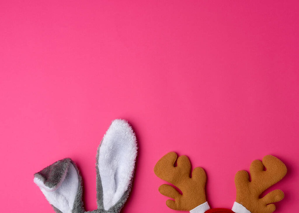 orejas sobresalientes de una máscara de conejo y cuernos de ciervo marrón en un rosa
  - Foto, imagen