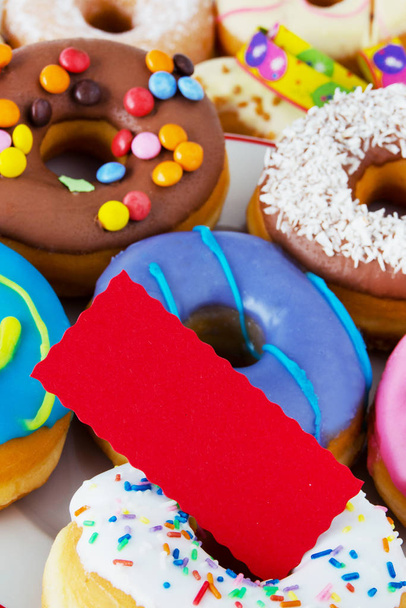 Colorful donuts with red label background - Foto, afbeelding