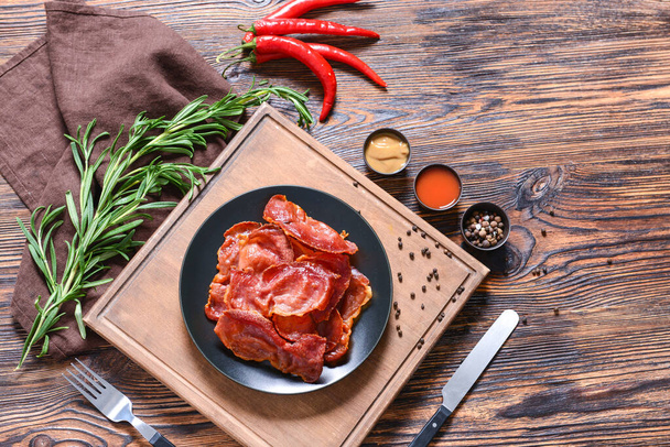 Plate with tasty fried bacon on wooden table - Photo, Image