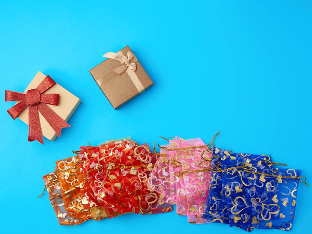textile gift bags and cardboard boxes on a blue background - Photo, Image