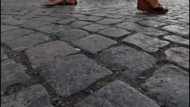 Menschen gehen die Kopfsteinpflasterstraße hinunter - Filmmaterial, Video