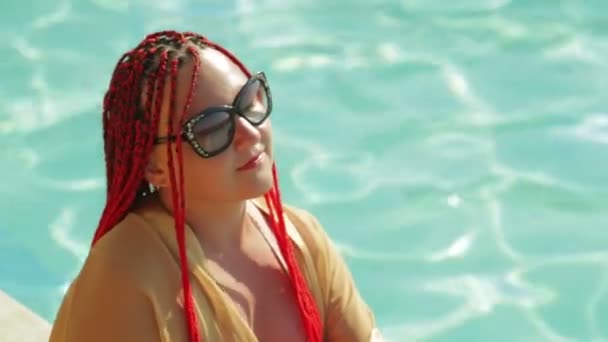A young woman is sitting at the edge of the pool - Filmagem, Vídeo