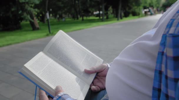 close-up van een oudere man lezen in park - Video