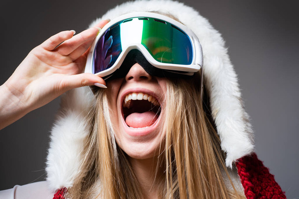 Ski mask. Sport. Extreme sport. Winter leisure. Laughing happy girl with ski mask on grey background. Snowboard glasses. Winter activities. Winter sport and activity. Portrait of a happy young girl - Fotografie, Obrázek