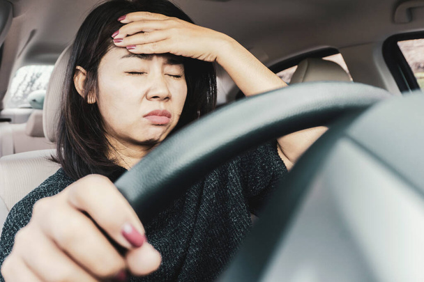 stressato donna asiatica che soffre di mal di testa e stanco con ingorgo stradale durante la guida di auto sulla strada
   - Foto, immagini