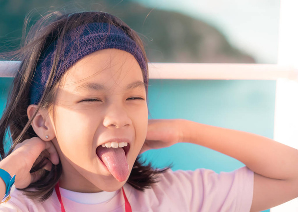 Little asian girl with tongue out for funny expression and amusi - 写真・画像