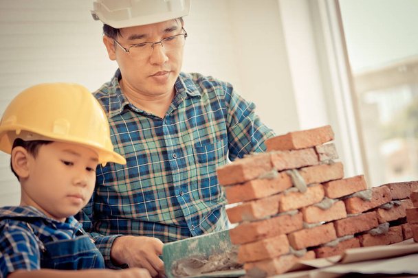 Little boy is learning how to lay down brick work from his build - Foto, Bild