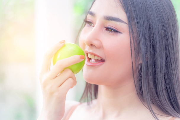 Женщина в хорошей форме ест зеленое яблоко для здоровой пищи и
 - Фото, изображение