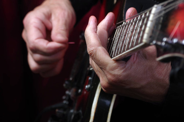 Handen van de gitarist en gitaar close-up. elektrische gitaar spelen. - Foto, afbeelding