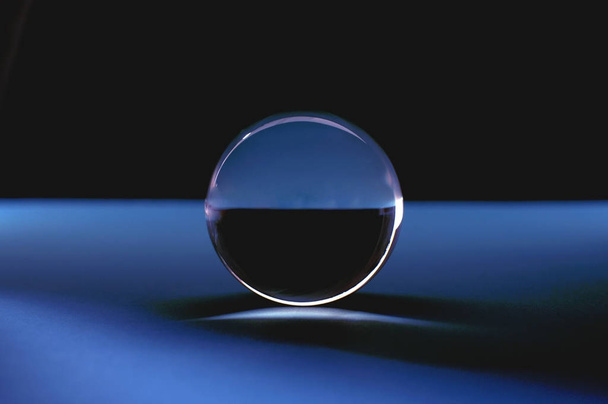 青い光の中でクリスタルボール。透明なガラス玉 - 写真・画像