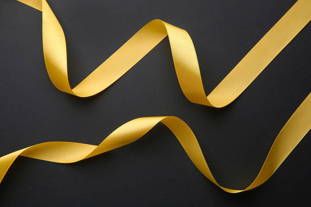 Beautiful golden ribbons on dark background - Photo, Image