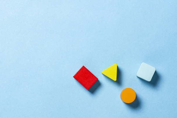 Дитячі освітні іграшки геометричні форми для логіки на синьому фоні. Концепція освіти, розвиток дитини, логіка та винахідливість. Плоский прошарок, вид зверху
 - Фото, зображення