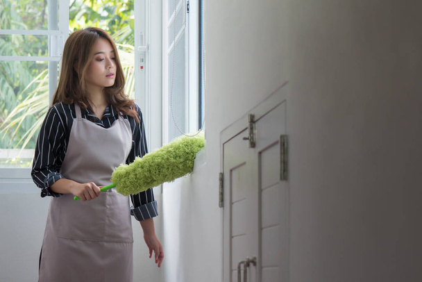 aziatische vrouw schoonmaken van ramen doen huishoudelijk werk met stofdoek - Foto, afbeelding