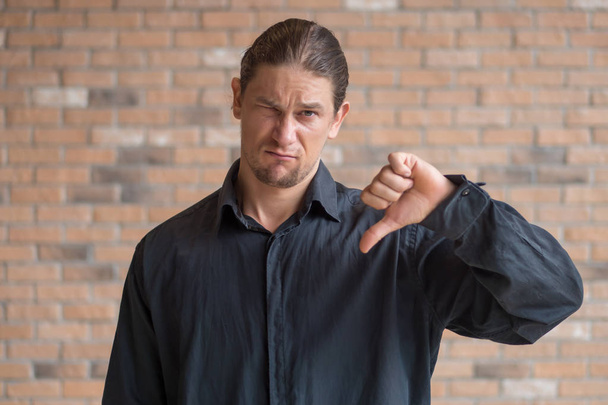boldogtalan frusztrált férfi mutatja hüvelykujját lefelé gesztus - Fotó, kép