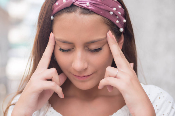 Porträt einer gestressten kranken Frau mit Kopfschmerzen; kranke Frau leidet unter Schwindel, Migräne, Kater, Gesundheitskonzept; junge erwachsene hispanische Latina-Frau - Foto, Bild