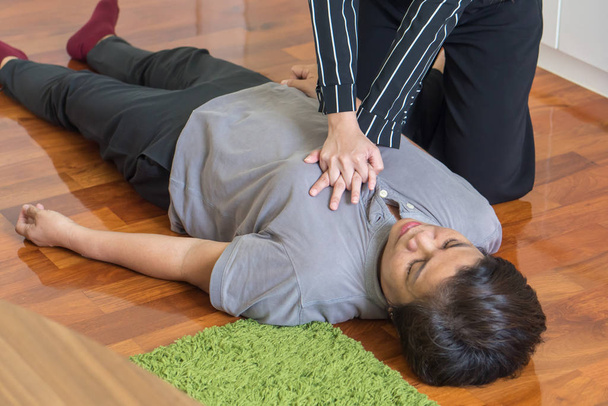 young woman doing CPR first aid to middle aged or senior unconscious woman; home first aid emergency rescue concept - Φωτογραφία, εικόνα