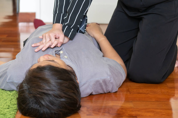 young woman doing CPR first aid to middle aged or senior unconscious woman; home first aid emergency rescue concept - Photo, Image