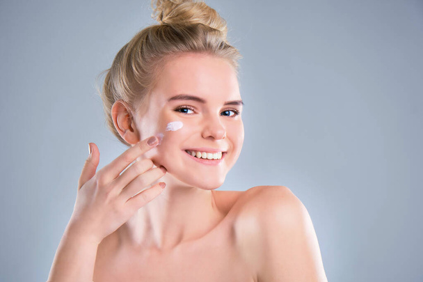 Giovane donna con crema cosmetica su un viso fresco e pulito. Stile di vita sano concetto
 - Foto, immagini