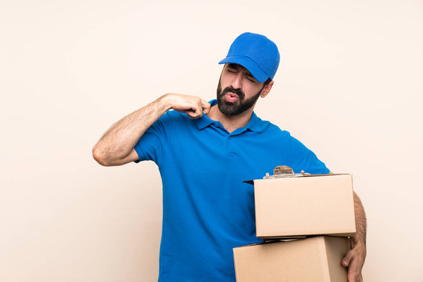 Delivery man with beard over isolated background with tired and sick expression - Photo, image