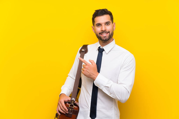 Handsome businessman over isolated yellow background pointing finger to the side - Foto, imagen