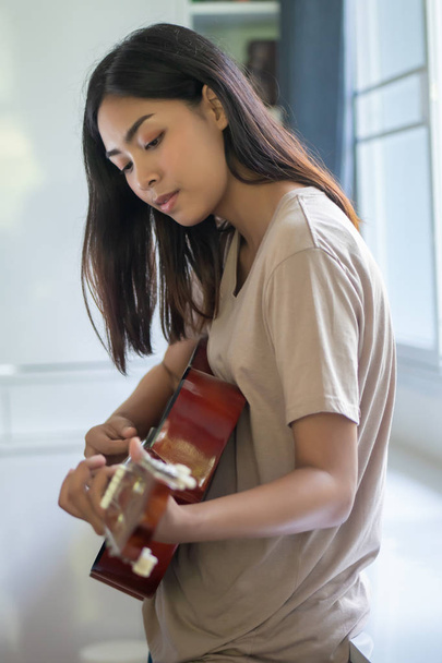 woman playing, practicing guitar; concept of music, hobby, relaxation - Foto, Imagen