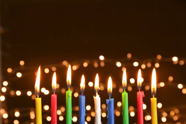 brennende Kerzen für Chanukka vor dunklem Hintergrund mit defokussiertem Licht - Foto, Bild