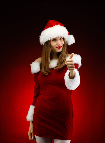 Woman in santa hat gesturing posing in studio - Foto, afbeelding