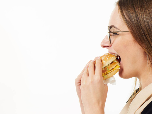chica comiendo una hamburguesa sobre un fondo blanco
 - Foto, imagen
