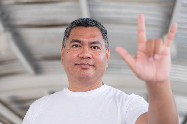 feliz sorrindo asiático sênior homem apontando para cima amor e paz mão sinal
 - Foto, Imagem