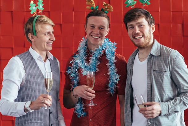 Három fiatalember ünnepli a karácsonyt vagy az újévet. - Fotó, kép