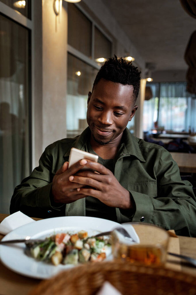 young african american man using laptop in cafe - Foto, imagen
