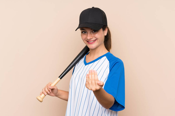 Young girl playing baseball over isolated background inviting to come with hand. Happy that you came - 写真・画像