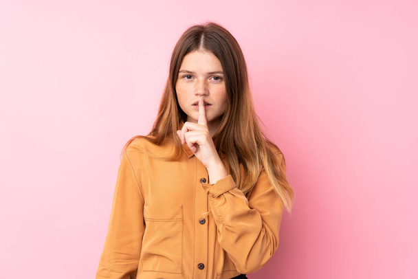 Ukrainian teenager girl over isolated pink background showing a sign of silence gesture putting finger in mouth - Foto, Bild