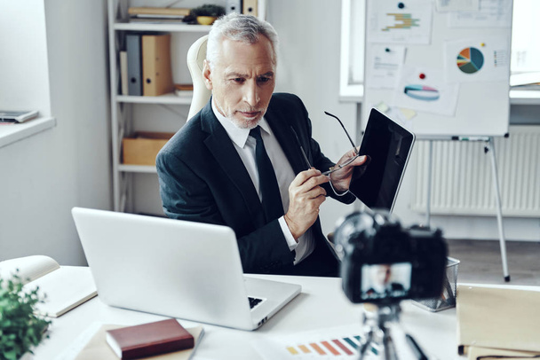 Senior man in elegant business suit using digital tablet while making social media video - Fotoğraf, Görsel