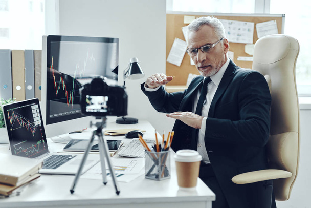 Senior man in elegant business suit using modern technologies while making social media video - Valokuva, kuva