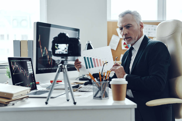 Senior man in elegant business suit showing graph while making social media video - Фото, зображення