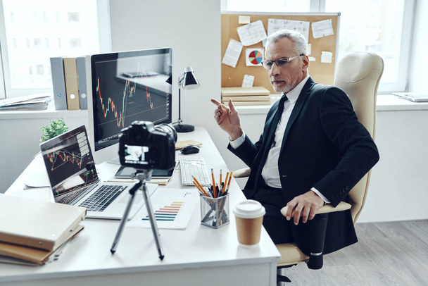 Senior Mann im eleganten Business-Anzug nutzt moderne Technologien und macht Social-Media-Video - Foto, Bild