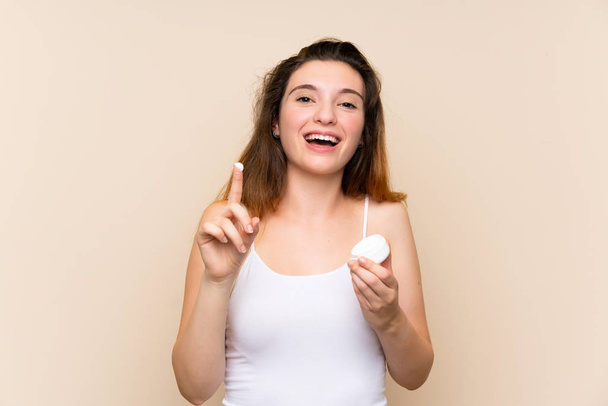 Молодая брюнетка девушка с увлажняющим кремом на изолированном фоне
 - Фото, изображение