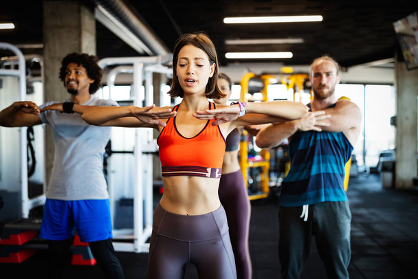 Fitness, sport, training and lifestyle concept. Group of fit people exercising in gym - Photo, Image