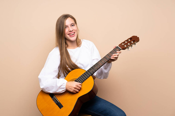 Teenager girl with guitar over isolated background - Foto, Bild