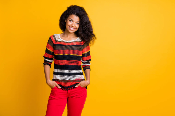 Portrait of nice attractive lovely winsome content cheerful cheery wavy-haired girl in knitted sweater holding hands in pockets isolated on bright vivid shine vibrant yellow color background - Фото, зображення