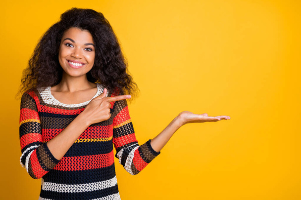 Close-up portrait of her she nice attractive cheerful cheery wavy-haired girl in knitted sweater demonstrating invisible object ad isolated on bright vivid shine vibrant yellow color background - Fotoğraf, Görsel