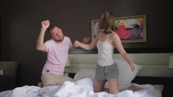man and woman are dancing on bed in bedroom in morning - Footage, Video