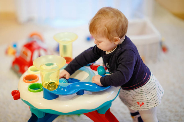 entzückend süße schöne kleine Mädchen spielen mit pädagogischen Sortierspielzeug zu Hause oder im Kinderzimmer. gesundes, glückliches Kleinkind lernt Farben und Formen sortieren - Foto, Bild
