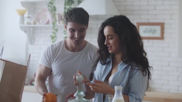 Portrait of happy couple cooking breakfast. Young married couple having fun. - Video, Çekim