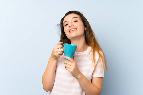 Genç esmer kız izole edilmiş arka planda bir fincan kahve tutuyor. - Fotoğraf, Görsel