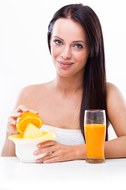 vrouw met een fruitpers en sinaasappelen - Foto, afbeelding